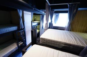 2 łóżka piętrowe w pokoju z oknem w obiekcie Cavemen Hostel Taipei Station Youth Branch w Tajpej