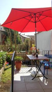 una sombrilla roja sobre una mesa de picnic en un patio en Garden in Florence, en Florencia