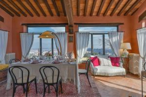 a dining room with a table and chairs and windows at Villa Casalguidi by PosarelliVillas in Cantagrillo