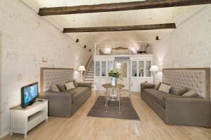 un soggiorno con due divani e un tavolo di B&B C'era una volta ad Alberobello