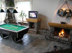 a living room with a pool table and a fireplace at Perlyna Karpat in Slavske