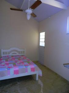 - une chambre avec un lit et un ventilateur de plafond dans l'établissement Hospedagem Conservatoria-Suites, à Conservatória