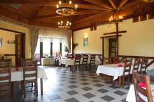 a restaurant with tables and chairs and a cross on the wall at Perlyna Karpat in Slavske