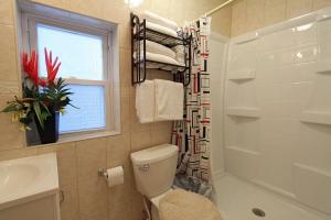 a bathroom with a toilet and a sink and a window at Shore Beach Houses - 38 Dupont Avenue in Seaside Heights