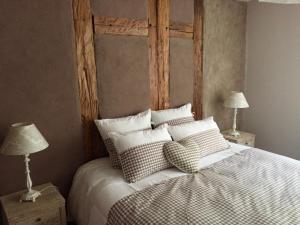 una camera da letto con letto, testiera e cuscini in legno di Les Authentics - La Maison d'Amélie a Riquewihr