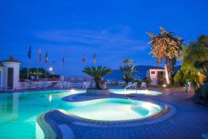 a swimming pool at night with lights on at Hotel Internazionale in Ischia