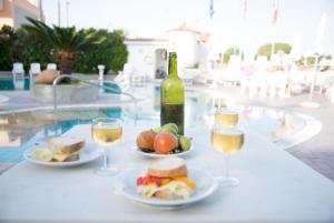 una mesa con dos platos de comida y copas de vino en Hotel Internazionale, en Isquia