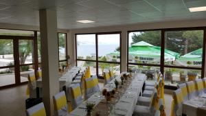 a long dining room with white tables and yellow chairs at Saint George Hotel 1 in Balchik