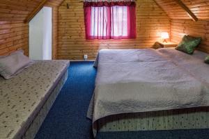 a bedroom with two beds in a wooden cabin at Chata Kamenár in Ružomberok