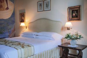 a bedroom with a white bed and a table with flowers at Hotel Villa Liana in Florence +105 photos
