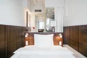 a bedroom with two beds and a mirror at Ruby Lilly Hotel Munich in Munich