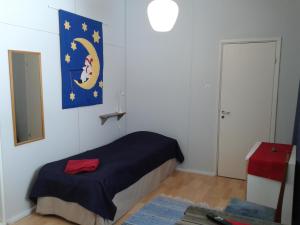 a bedroom with a bed with a blue blanket at Matkustajakoti Kuutamo Guesthouse in Suomussalmi