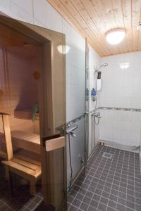 a bathroom with a shower and a bench in it at Matkustajakoti Kuutamo Guesthouse in Suomussalmi
