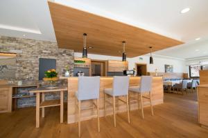 a kitchen with a bar with chairs and a table at Hotel Lipeter & Bergheimat in Weissensee