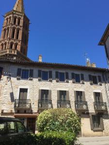 a building with a clock tower in the background at B&B Le Chat Qui Dort in Montricoux