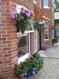 a brick building with flowers in a window at Taylors Guesthouse in Salisbury