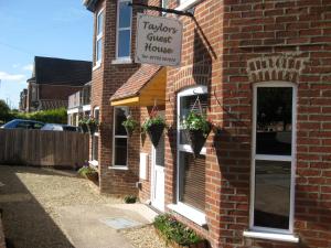 um edifício de tijolos com um sinal para uma casa de hóspedes de carrinho em Taylors Guesthouse em Salisbury