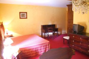 une chambre d'hôtel avec un lit et une télévision dans l'établissement Les Chambres d'hôtes Benoit Breton, à Bulgnéville