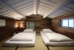 台南的住宿－屎溝墘客廳，木墙客房的两张床