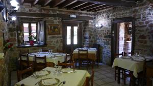 a restaurant with tables and chairs in a room with stone walls at Hotel Rural Los Texos in La Riera