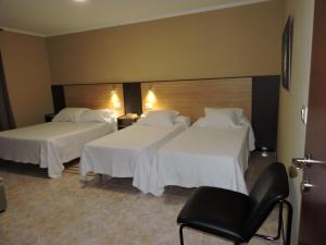 a hotel room with two beds and two tables at Cruceiro do Monte in Tui
