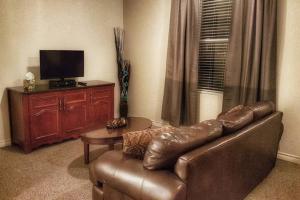 a living room with a leather couch and a tv at Cozy Little Apartment #11 by Amazing Property Rentals in Gatineau