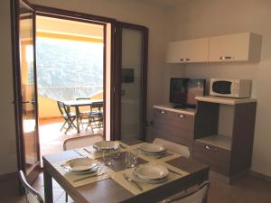 Appartamento Mirto في بوجيرو: مطبخ مع طاولة وغرفة طعام
