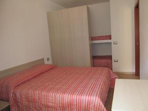 - une chambre avec un lit et une couverture rouge rayée dans l'établissement Appartamento Mirto, à Buggerru