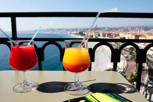 two drinks sitting on a table on a balcony at Hotel Suisse in Nice