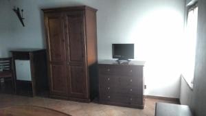 un soggiorno con cassettiera, TV e mobile in legno di Villa Asiola a Villa Vicentina