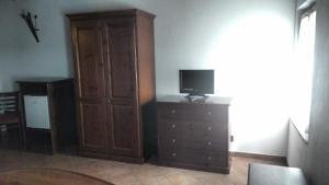 a living room with a dresser and a tv and a wooden cabinet at Villa Asiola in Villa Vicentina