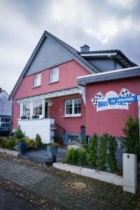 a pink house with a sign on the side of it at The Place After the Race B&B in Müllenbach
