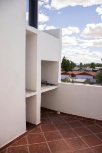 a white wall with a shelf on a balcony at Apartaments Orquera in Sarmiento
