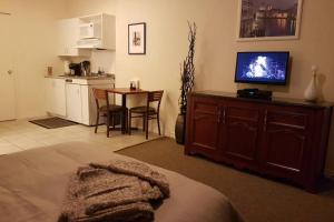 een woonkamer met een televisie en een tafel met stoelen bij Cozy Little Studio #16 by Amazing Property Rentals in Gatineau
