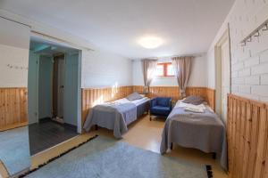 a bedroom with two beds and a blue chair at Hotelli Uninen Tampere in Tampere