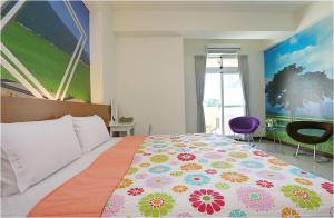 een slaapkamer met een groot bed en een kleurrijk dekbed bij Sweet Home in Taitung in Taitung