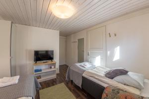 a bedroom with two beds and a television in it at Hotelli Uninen Tampere in Tampere