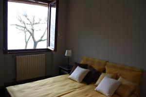 1 dormitorio con 1 cama con un árbol en la ventana en Villa Carla en Meina
