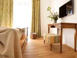 a bedroom with a desk with a television on a wall at Brandtner Komfortzimmer in Kaumberg