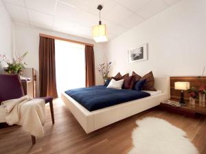 Schlafzimmer mit einem Bett mit blauer Bettwäsche und einem Fenster in der Unterkunft Brandtner Komfortzimmer in Kaumberg