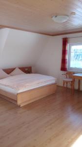 1 dormitorio con cama, mesa y ventana en Pension Forsthaus Täle, en Titisee-Neustadt