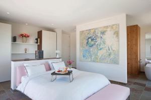 - une chambre avec un lit blanc et une table dans l'établissement BB 12 LUBERON chambres d'hôtes contemporaines, à Gordes 64 autres photos