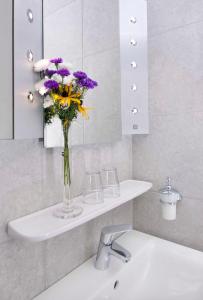 La salle de bains est pourvue d'un lavabo avec un vase de fleurs. dans l'établissement Brandtner Komfortzimmer, à Kaumberg