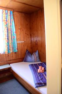 ein kleines Bett in einer Holzhütte mit einem Fenster in der Unterkunft Bungalow Pipp in Passriach