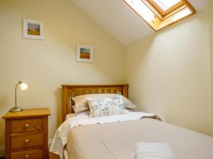 a bedroom with a bed and a skylight at Sanderling Home in Aldeburgh