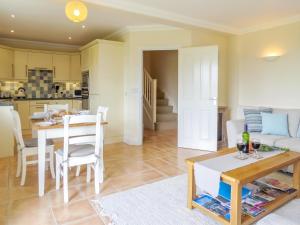een keuken en een woonkamer met een tafel en stoelen bij Sanderling Home in Aldeburgh
