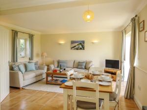 een woonkamer met een tafel en een bank bij Sanderling Home in Aldeburgh