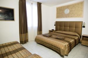 a hotel room with two beds and a window at Hotel Europa in Modena