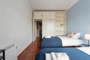 リスボンにあるBeautiful view close to Estádio da Luzのベッド2台とクローゼットが備わる小さな客室です。