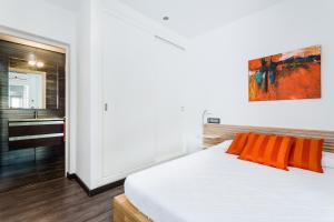 カン・ピカフォルトにあるCa Sa Padrina by LOCALITEのベッドルーム1室(オレンジ色の枕とシンク付きのベッド1台付)
